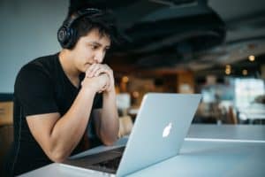 Man with headphones focusing on laptop