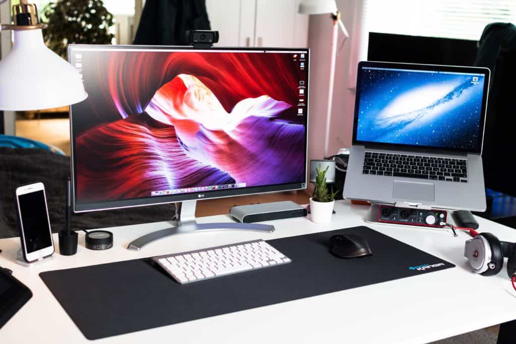 Desk setup with external monitor, peripherals, and a laptop